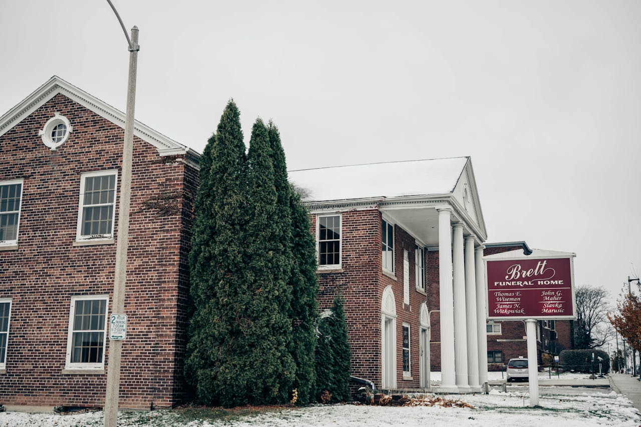 Snowy day view of Brett Funeral Home in Milwaukee, Wisconsin showcasing classic brick architecture.